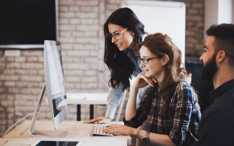 download lead ads facebook: image of three professionals looking at a computer screen