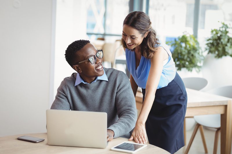 Facebook ads: image of two executives talking and smiling while using a laptop