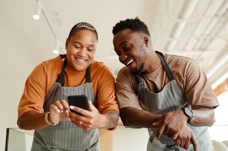 Whatsapp Facebook ads: Image of colleagues browsing the internet on their smartphone