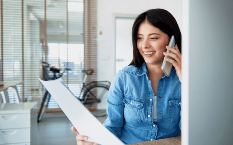 Paid traffic: woman in jeans, on the phone and smiling.