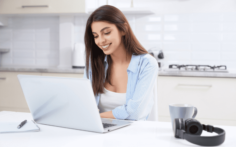 YouTube Ads: woman smiling, wearing a light blue shirt and looking at her computer.